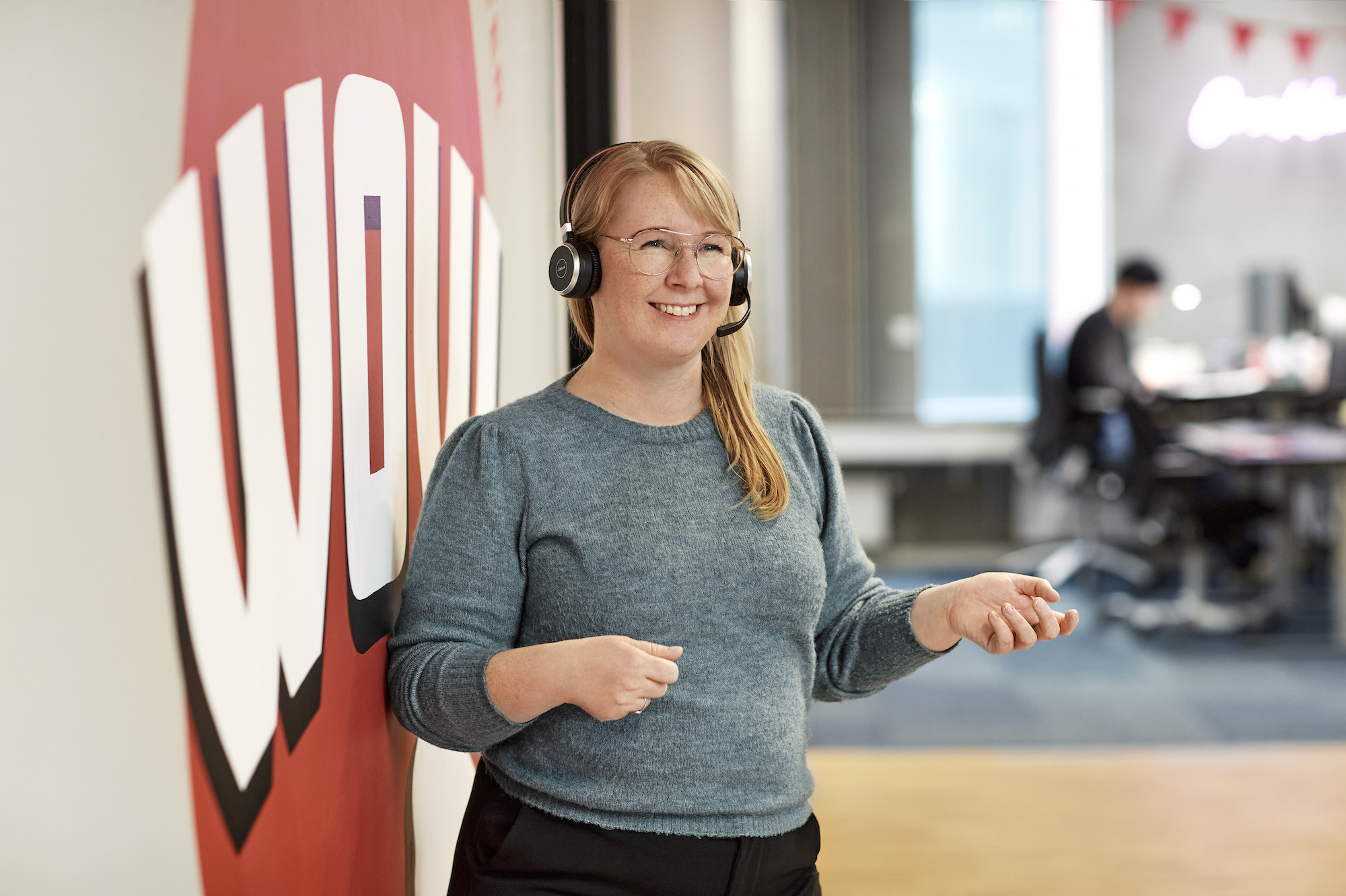 En kvinde står i en support-afdeling og taler i et headset