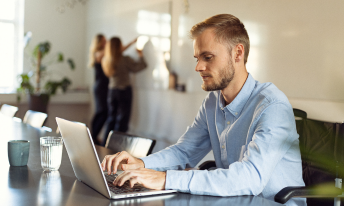 En mand sidder og kigger på sin computer