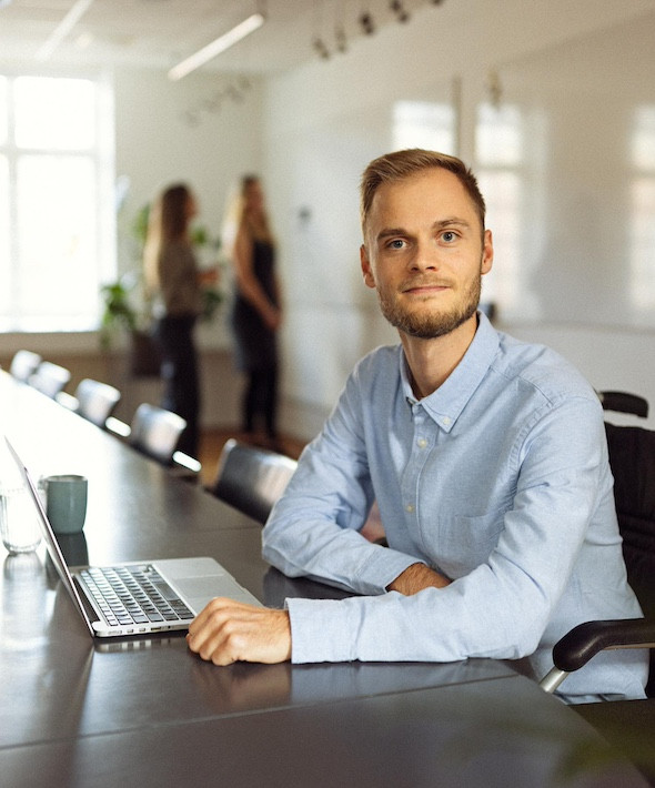 En mand sidder ved en computer og arbejder med regnskab